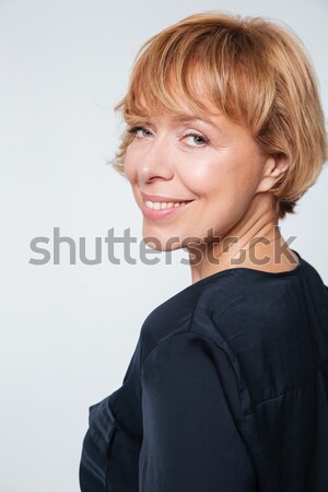 Close up image of smiling elderly woman standing sideways Stock photo © deandrobot