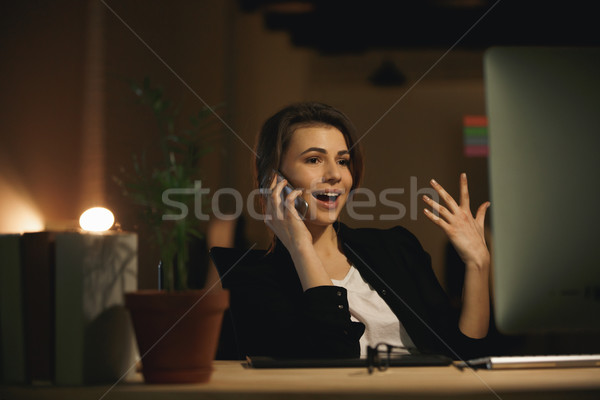 Stock photo: Emotional young woman designer talking by phone.