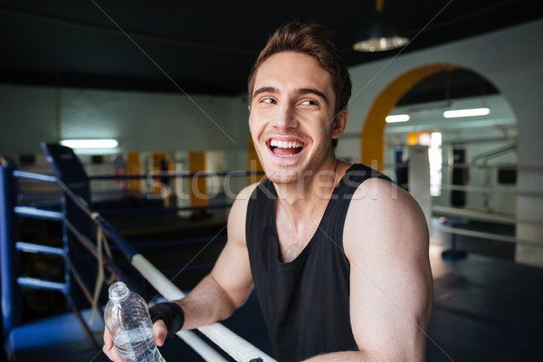 Side view of laughing boxer relaxing in boxing ring Stock photo © deandrobot