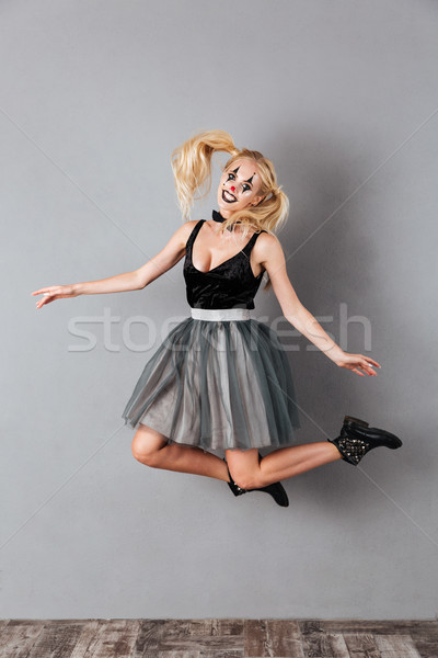 Full length image of smiling blonde woman in halloween make-up Stock photo © deandrobot