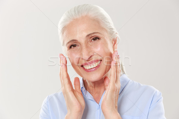 Close-up photo of laughing gray-haired senior woman, looking at  Stock photo © deandrobot