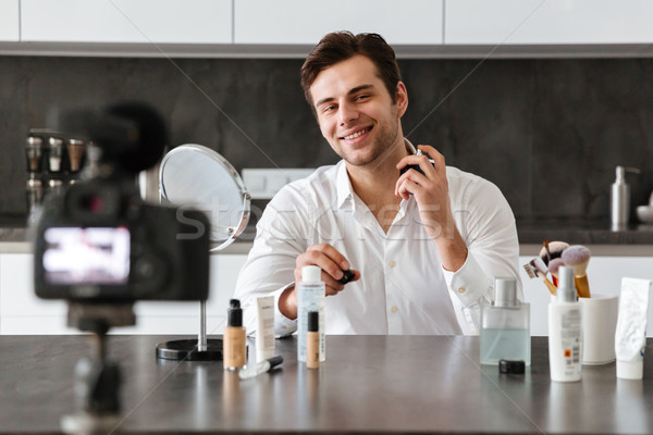 Smiling young man filming his video blog episode Stock photo © deandrobot