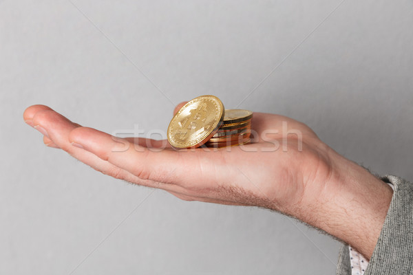 Close up of man showing stack of golden bitcoins Stock photo © deandrobot