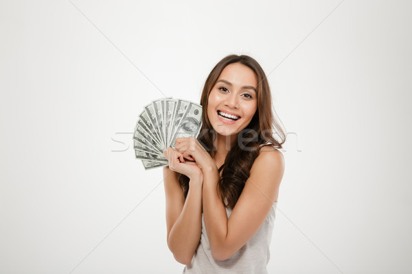Photo of lucky smiling woman with long hair winning lots of mone Stock photo © deandrobot