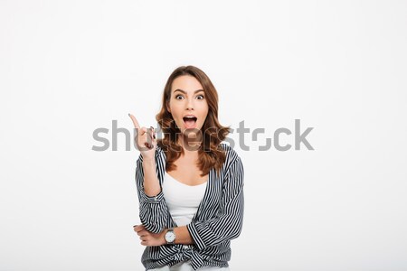 Stock photo: Portrait of an excited casual girl pointing finger up