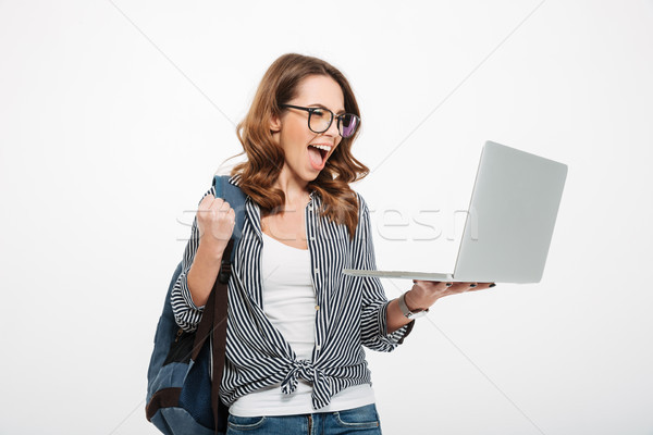 Shocked happy young lady using laptop computer Stock photo © deandrobot