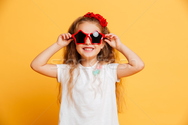 Little cute smiling girl wearing sunglasses looking camera. Stock photo © deandrobot