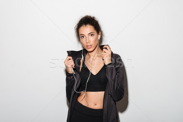 Attractive curly brunette fitness woman listening music Stock photo © deandrobot