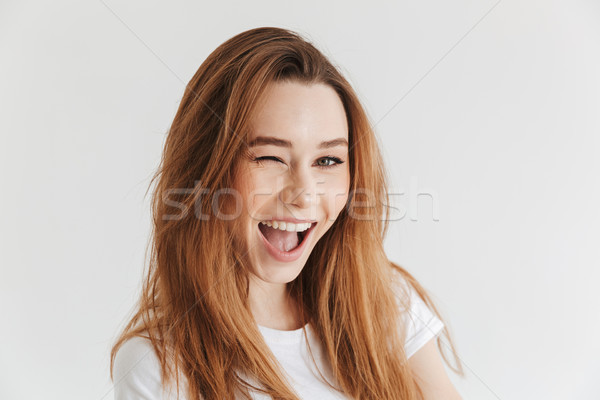 Happy woman in t-shirt winks her eye Stock photo © deandrobot