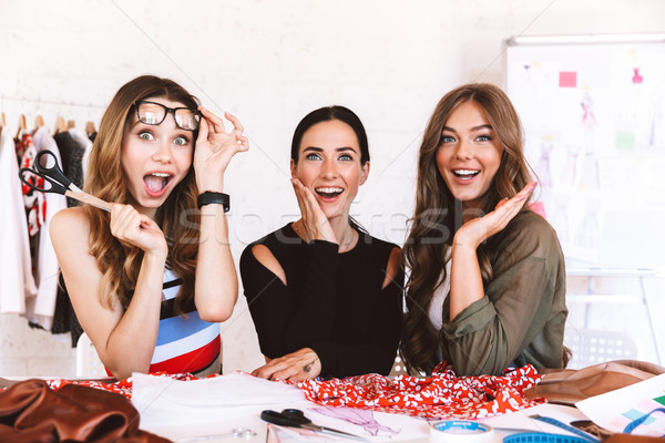 Three joyful young women clothes designers Stock photo © deandrobot