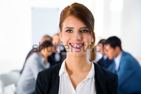 Portrait of a smiling woman standing in front of a business meeting Stock photo © deandrobot