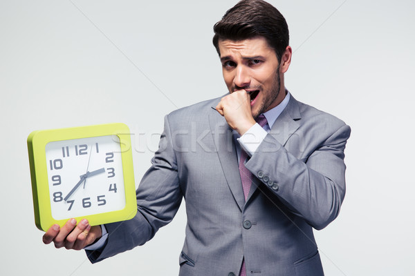 Worried businessman holding clock Stock photo © deandrobot