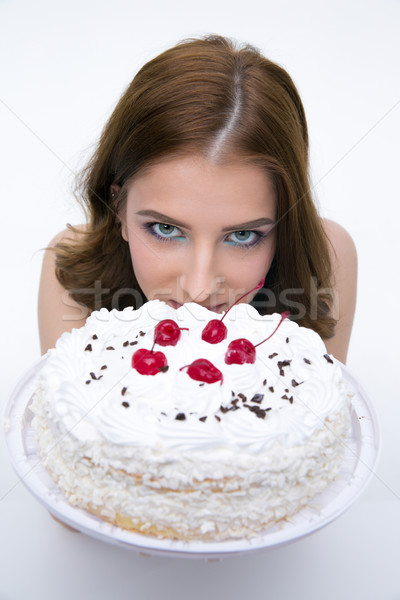 Portrait of a beautiful woman with cake over gray background Stock photo © deandrobot