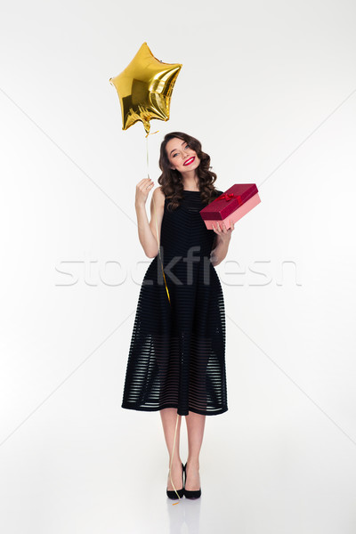 Smiling woman holding golden star shaped balloon and present box Stock photo © deandrobot