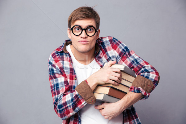 Amusing comical young male in round glasses holding books  Stock photo © deandrobot