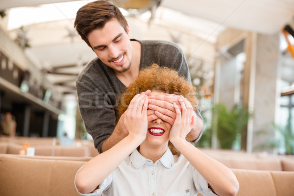 Man covering eyes to her girlfriend in restaurant Stock photo © deandrobot