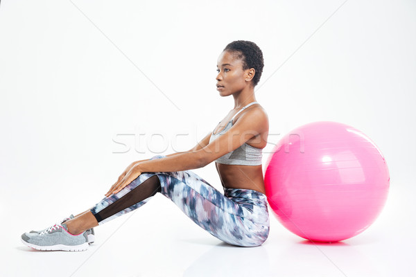 Beautiful young african american sportswoman sitting and posing with fitball  Stock photo © deandrobot