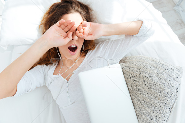 Stock photo: Woman waking up and rubbing her eyes