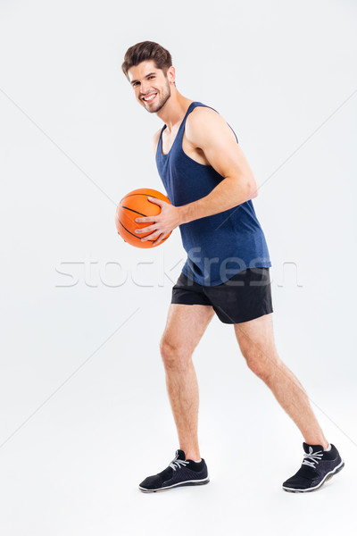 Full length portrait of a sports man playing in basketball Stock photo © deandrobot