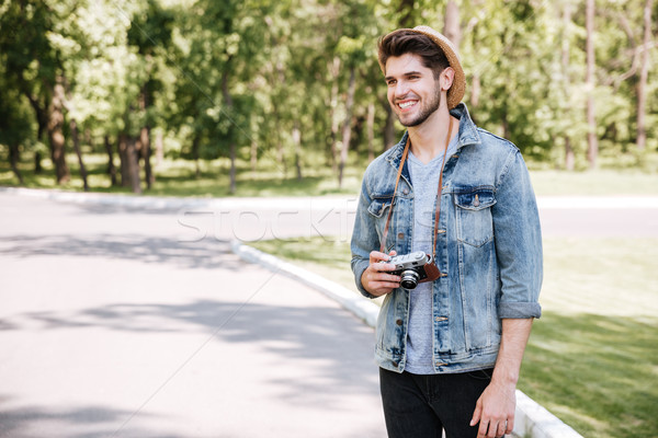 Happy young man in hat with old vintage photo camera Stock photo © deandrobot