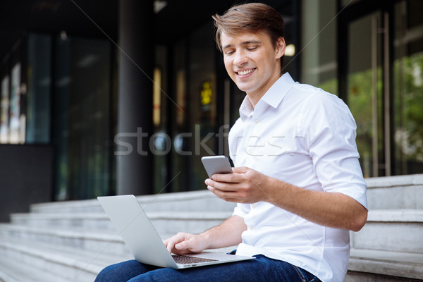 Foto stock: Empresário · telefone · móvel · laptop · ao · ar · livre · alegre · jovem