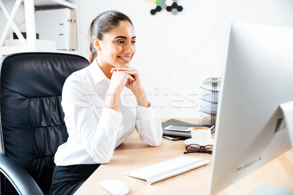 Feliz jóvenes mujer de negocios mirando pantalla del ordenador sesión Foto stock © deandrobot