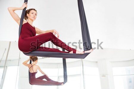Stock photo: Woman ballerina stretching near stick on wall in dance studio