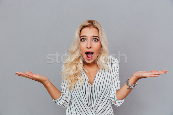 Portrait of surprised woman with mouth open standing Stock photo © deandrobot