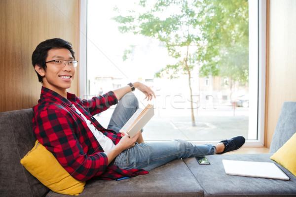 Alegre asiático estudante leitura livro universidade Foto stock © deandrobot