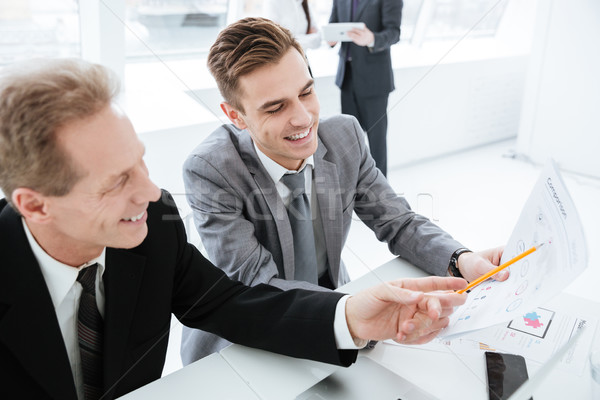 Cropped Business partners by the table with colleagues on background Stock photo © deandrobot