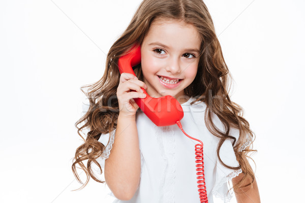 Cheerful cute little girl talking on red telephone Stock photo © deandrobot