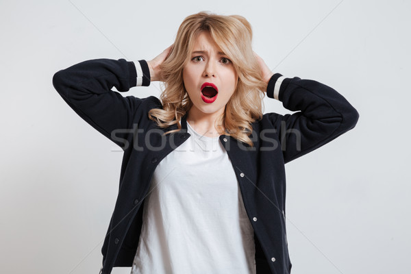 Portrait of a surprised astonished young woman looking at camera Stock photo © deandrobot