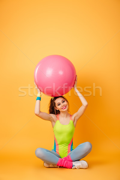Young sports woman posing over yellow background with fitness ball Stock photo © deandrobot