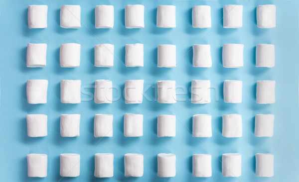 Top view picture of marshmallows over blue table background. Stock photo © deandrobot