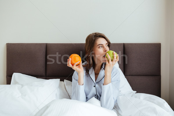 Asombroso jóvenes dama comer naranja manzana Foto stock © deandrobot