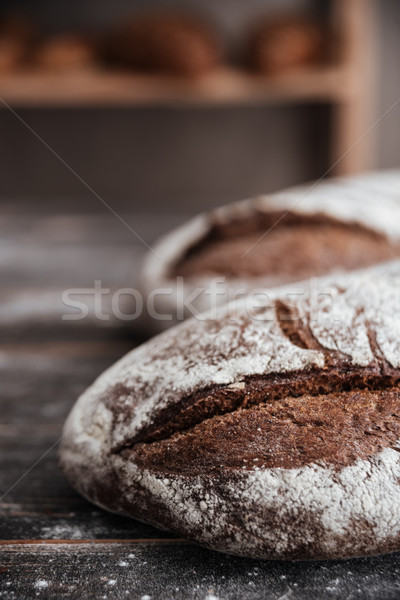 Bread with flour on dark wooden table Stock photo © deandrobot