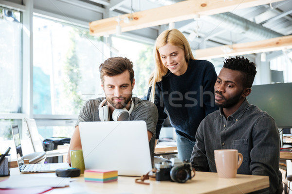 Happy colleagues sitting in office coworking. Stock photo © deandrobot