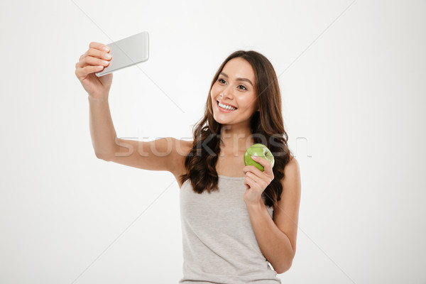 Picture of attractive charming woman making selfie on silver cel Stock photo © deandrobot
