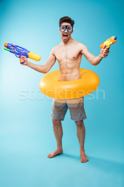 Full length portrait of an excited young shirtless man Stock photo © deandrobot
