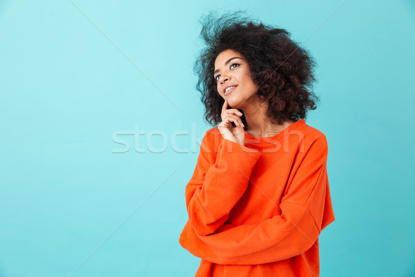 Thoughtful american woman in colorful shirt looking upward with  Stock photo © deandrobot