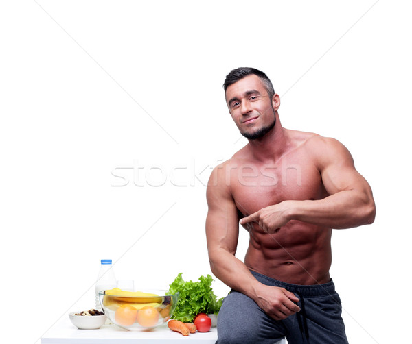 Feliz muscular hombre senalando alimentos saludables alimentos Foto stock © deandrobot