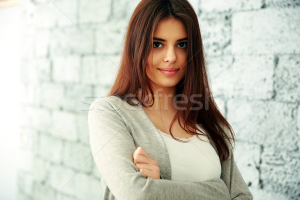 Stockfoto: Jonge · glimlachende · vrouw · armen · gevouwen · permanente · muur