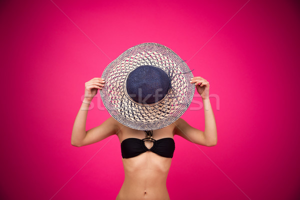 Woman in bikini covering her face with hat Stock photo © deandrobot