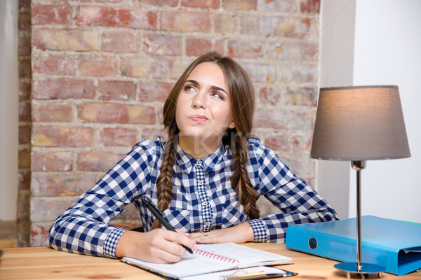 Woman sitting at the table and thinking about her homework Stock photo © deandrobot