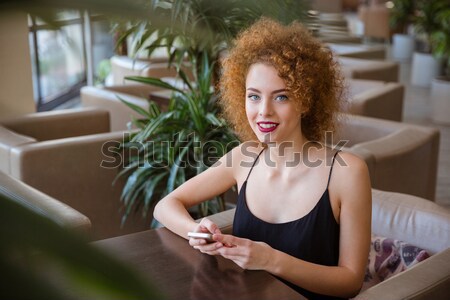Kobieta kręcone włosy posiedzenia tabeli restauracji szczęśliwy Zdjęcia stock © deandrobot