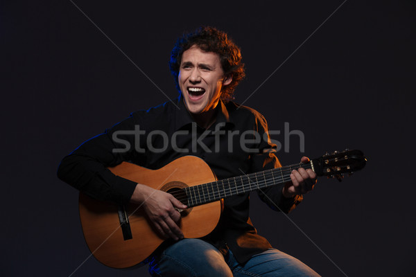 Wesoły człowiek gry gitara ciemne szczęśliwy Zdjęcia stock © deandrobot