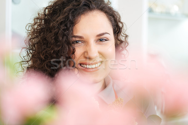 Cheeful attractive young woman with curly long hair  Stock photo © deandrobot