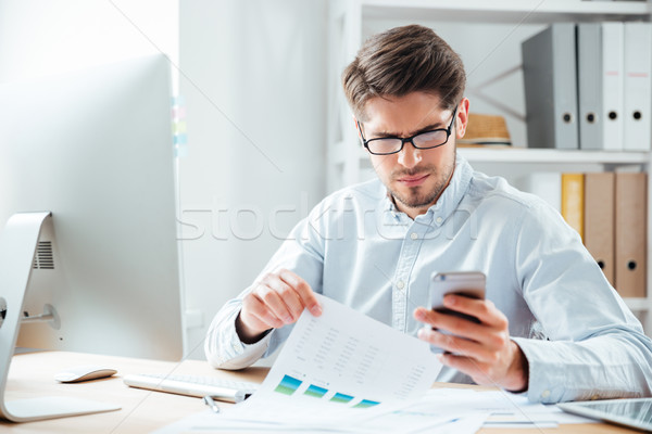 Portrait of a businessman using mobile phone in the office Stock photo © deandrobot