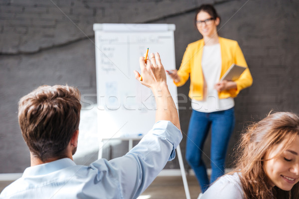 Back view of man sitting and asking questions on presentation Stock photo © deandrobot