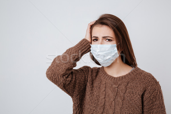 Nő pulóver orvosi maszk tart fej Stock fotó © deandrobot